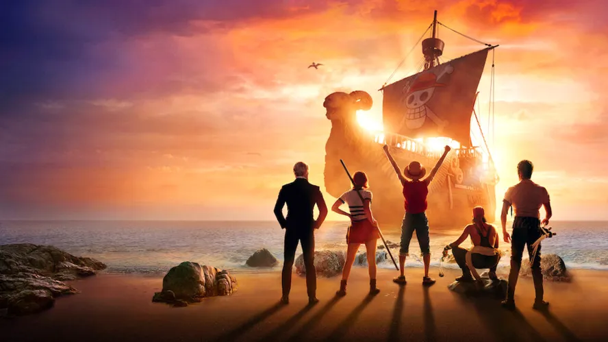 Jovens piratas empolgados na praia, de frente para um navio pirata