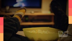 Imagem com clima de frio em São Paulo e ícones de streaming ao lado de um sofá e cobertor