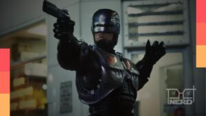 Ciborgue policial Marc Kyle em cenário urbano futurista, com James Wan ao fundo como referência de produção