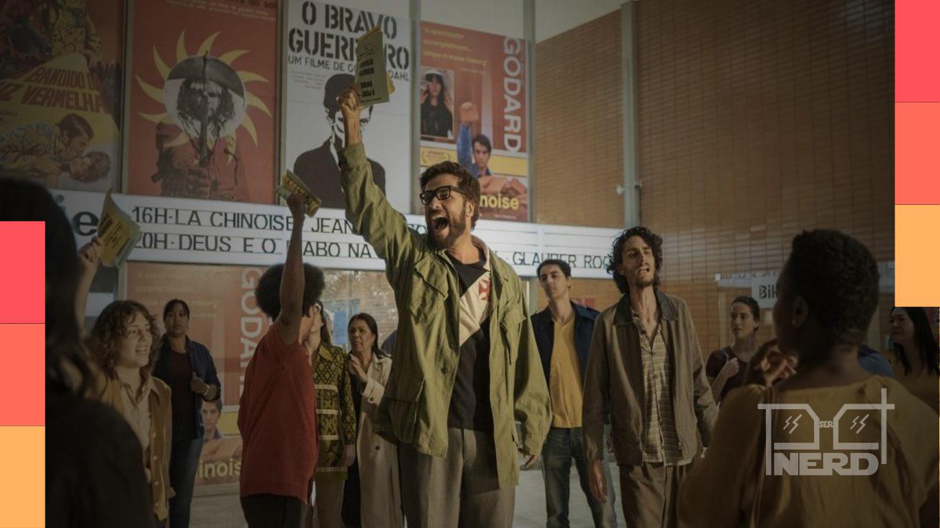 Bruno Gagliasso interpretando Honestino em cena com jovens ao redor e clima de protesto, ao fundo pôsteres de filmes antigos