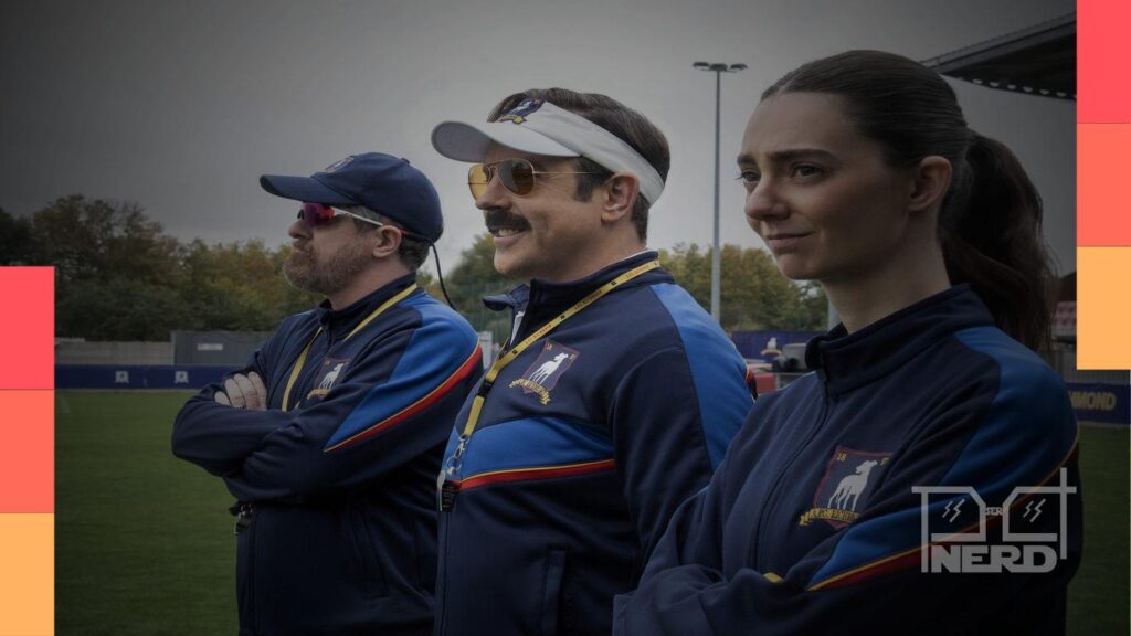 Cena da quarta temporada de Ted Lasso em campo, com treinadores observando um jogo