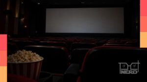 Pessoa assistindo a um filme em uma sala de cinema, com tela iluminada