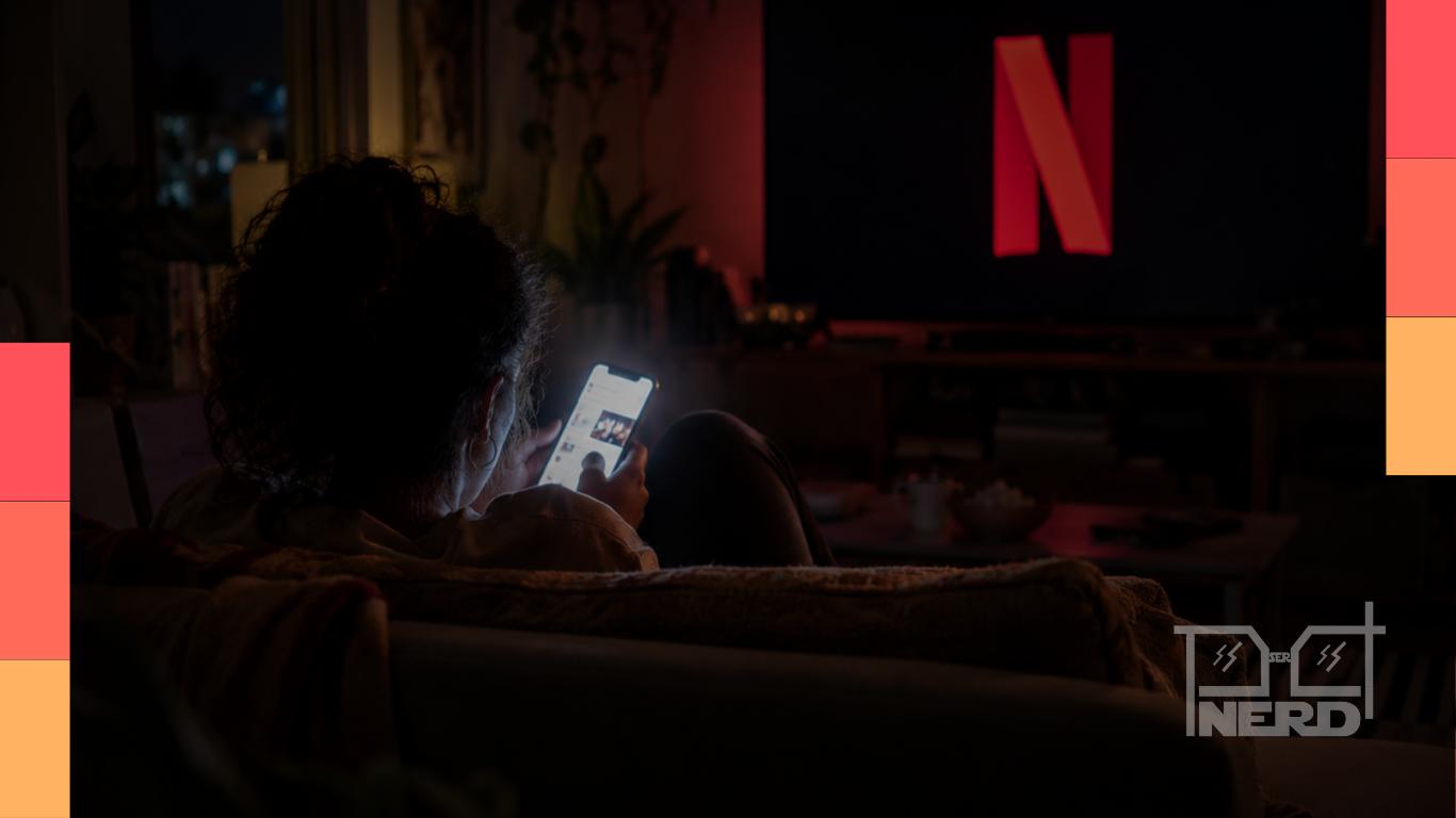 Espectadora divide a atenção entre uma série da Netflix e o celular